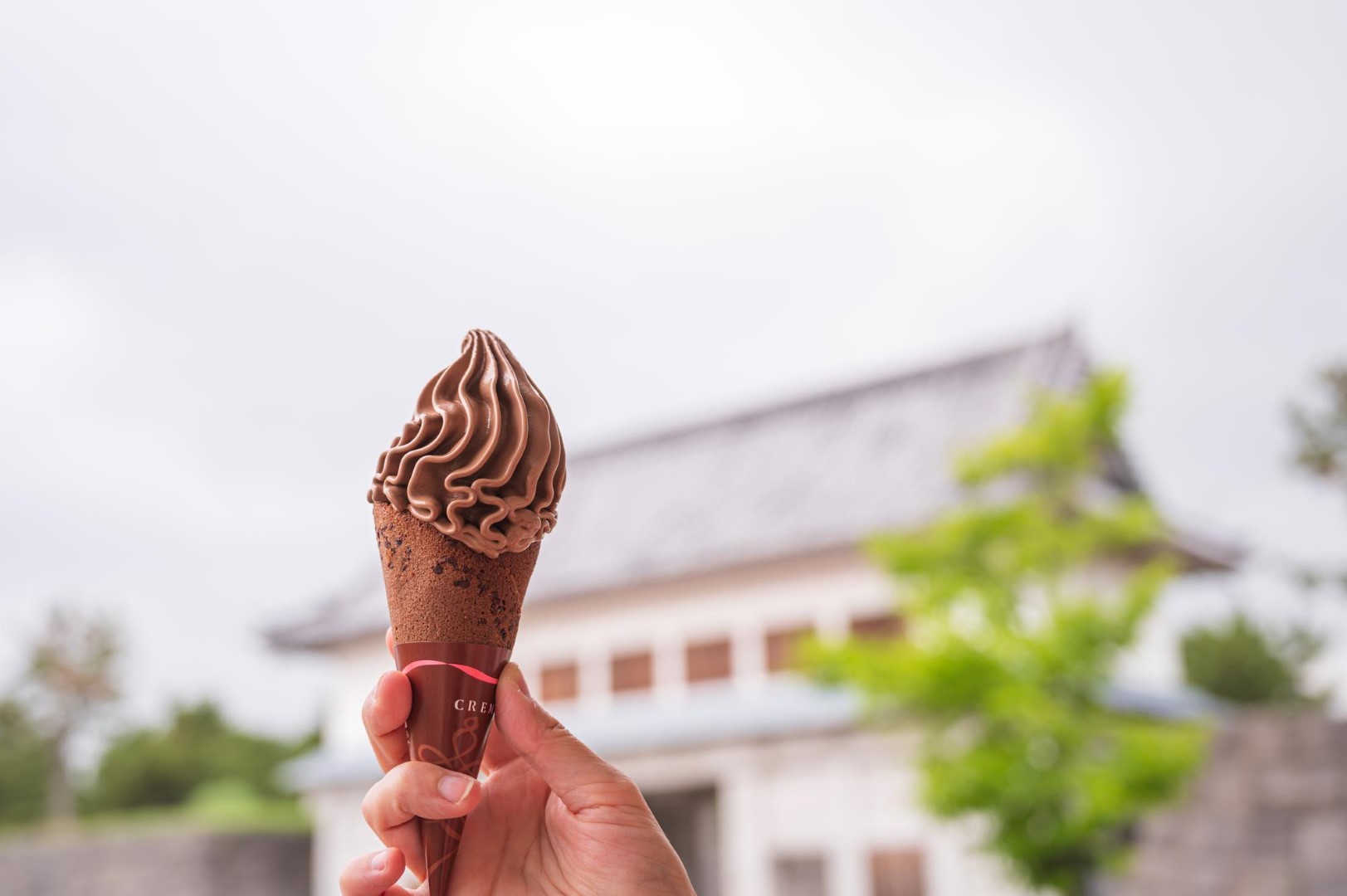 chocolate soft serve Woman outdoor  at summer sunset time having ice cream cone positive happy playful at city street