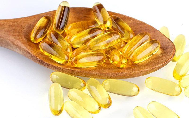 Fish-oil-tablets-on-spoon-on-white-table Fish-oil-tablets-on-spoon-on-white-table