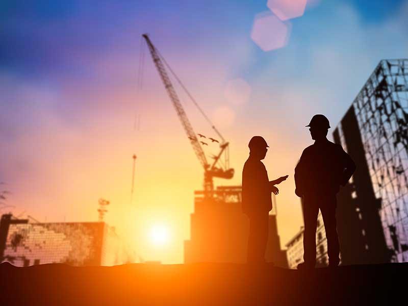 construction workers on site in sunset