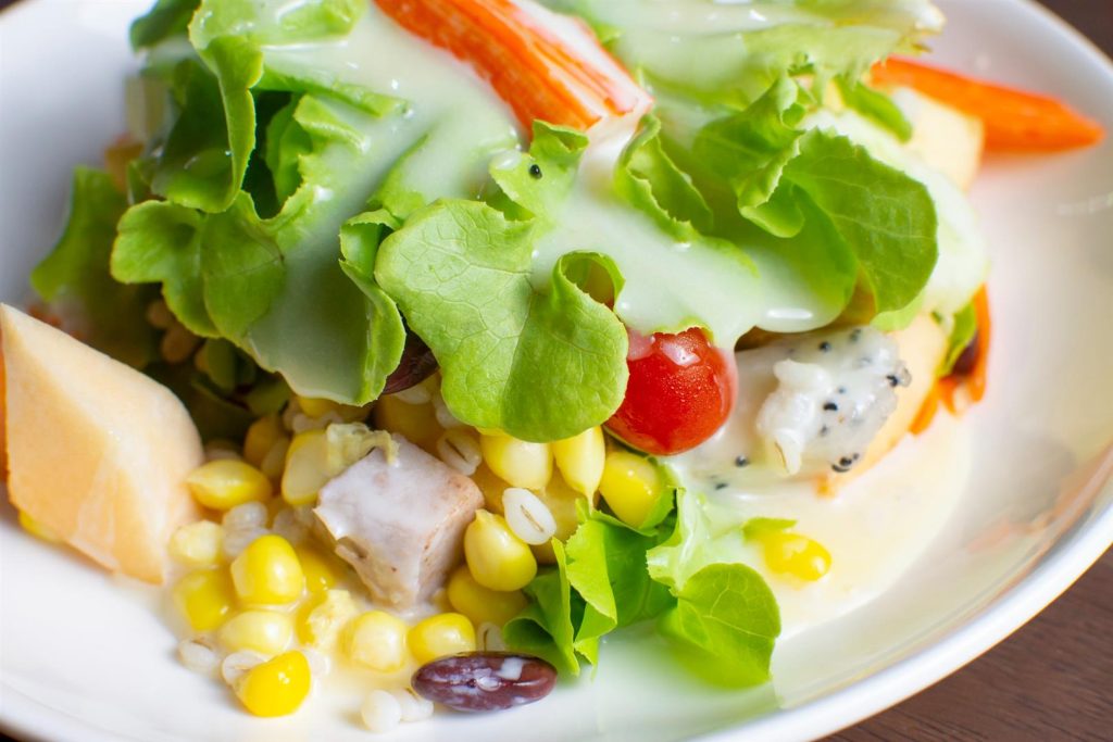 salad-with-fruit-fresh-vegetable-topped-with-salad-dressing-white-dish-wooden-table (Large)